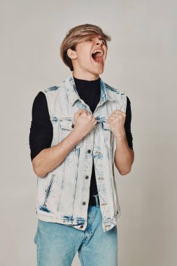 # Ağzı açık genç adam # # Gri arka planda bağır #