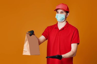 Kırmızı maskeli teslimatçı eleman, boş karton kutu.