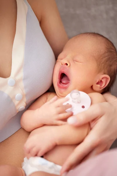 screaming newborn in the arms of mom