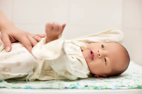 Mãe vestir sua filha bebê hewborn bonito — Fotografia de Stock