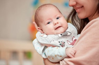 Genç anne yeni doğmuş bebeğine sarılıyor. Boşluğu kopyala