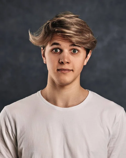 surprised young handsome guy on gray background. facial expressions