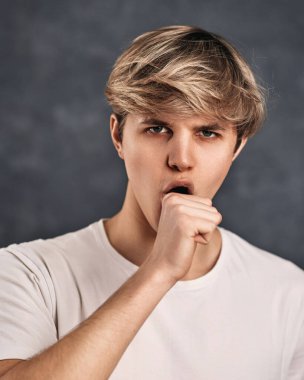 young handsome guy on gray background. guy doing fuck you bad expression
