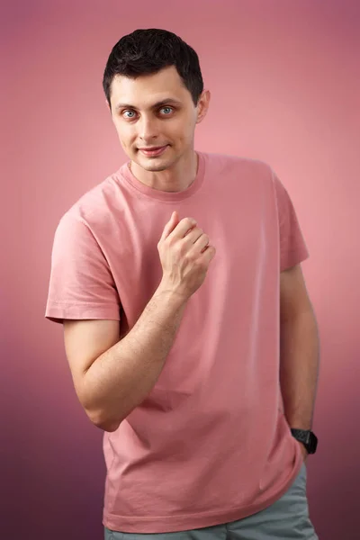 Pohledný Muž Tričku Při Pohledu Kameru Růžovém Pozadí — Stock fotografie
