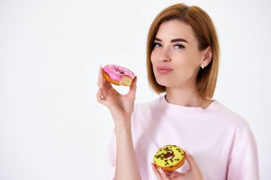 Beyaz arka planda izole edilmiş donutları olan güzel, sarışın bir kadın..