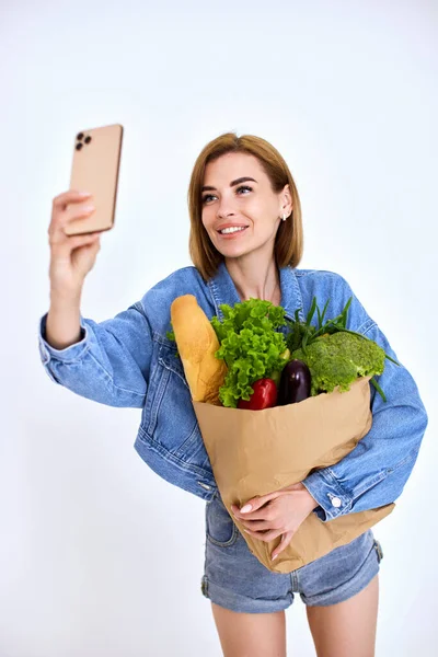 Beautiful Smiling Woman Holds Paper Bag Vegetables Doing Selfie Smart — 스톡 사진