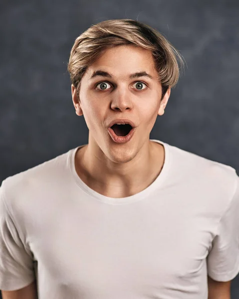 Sorprendido Joven Chico Guapo Sobre Fondo Gris Expresiones Faciales —  Fotos de Stock