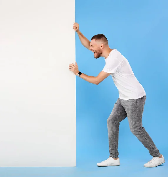 Cheerful Bearded Man Pushing Big Blank Banner Isolated Blue Background — Φωτογραφία Αρχείου