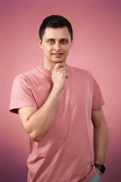 Handsome Thoughtful Man Touching Chin Hand Looking Camera Pink Background — стоковое фото