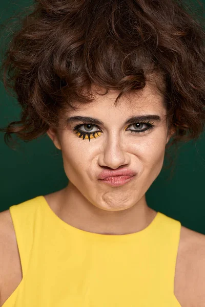 Young Curly Woman Creative Make Yellow Dress Grimaces Green Background — Fotografia de Stock