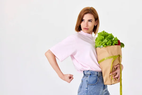 Sporty Woman Holds Paper Bag Vegetables Measuring Tape White Background — Foto de Stock