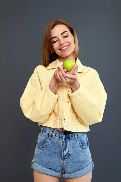 Усміхнена Весела Жінка Тримає Зелене Яблуко Ізольовано Сірому Фоні — стокове фото