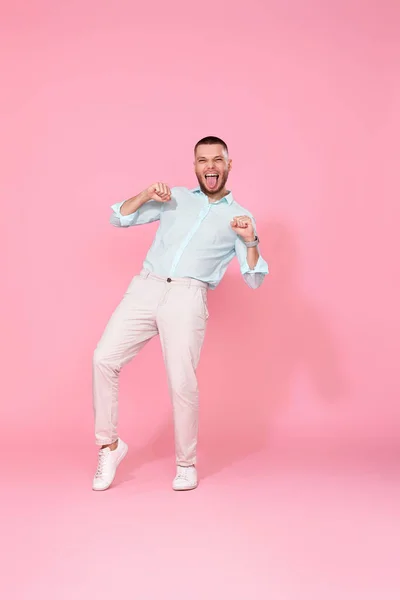 Handsome Smiling Man Blue Shirt Dancing Isolated Pastel Pink Background — Φωτογραφία Αρχείου