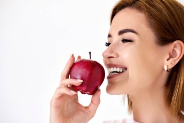 smiling pretty girl holding red apple isolated on white background. close-up