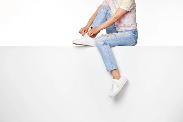 Female Legs Jeans White Sneakers Sitting White Banner Copy Space — Stock Photo, Image