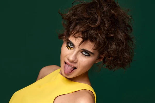 Young Curly Woman Creative Make Yellow Dress Grimaces Shows Tongue — Stockfoto