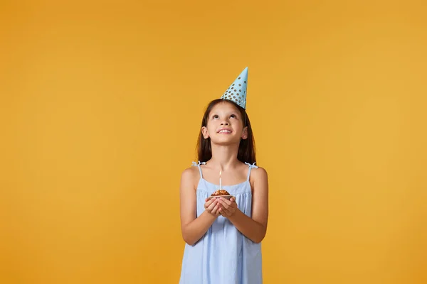 Ευτυχισμένο Κοριτσάκι Χωνάκι Κάνει Ευχή Στα Γενέθλιά Της Κίτρινο Φόντο — Φωτογραφία Αρχείου