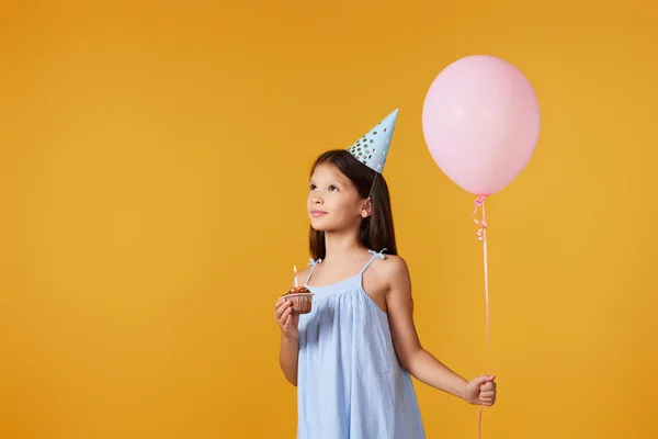 Niña Feliz Con Cono Fiesta Sosteniendo Cupcake Globo Cumpleaños Sobre —  Fotos de Stock