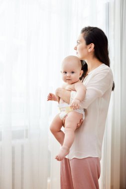Mutlu anne kucağında ve yeni doğmuş bebeğini kucağında tutuyor.