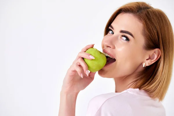 Piękna Kobieta Jedząca Zielone Jabłko Patrząca Kamerę Odizolowaną Białym Tle — Zdjęcie stockowe