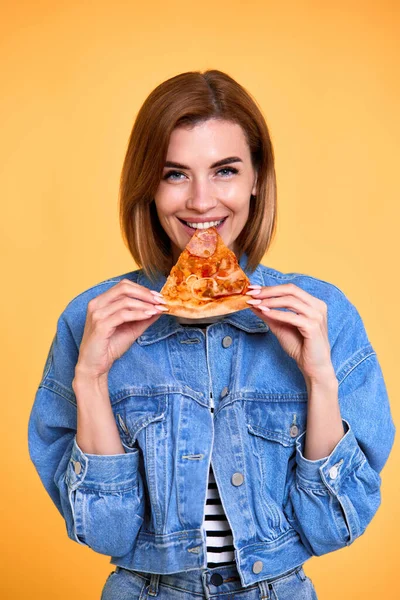 Щаслива Жінка Кусає Шматочок Піци Жовтому Фоні — стокове фото