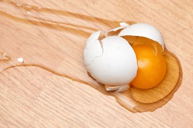 Mutfağın ahşap zemininde kırılmış yumurta.