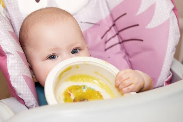 可愛い赤ちゃんの女の子は赤ん坊の椅子でマッシュ野菜を食べた — ストック写真