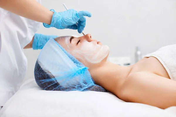 Esteticista Aplica Máscara Cara Hermosa Joven Salón Spa Envejecimiento Concepto — Foto de Stock