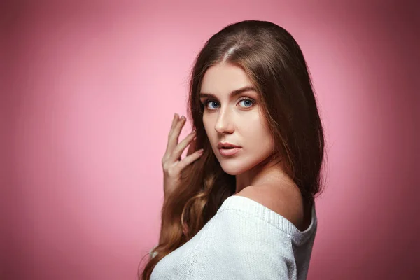 lovely woman with strong healthy curly hair looking at camera on pink background. copy space