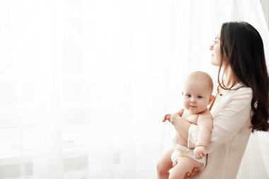 Mutlu anne kucağında ve yeni doğmuş bebeğini kucağında tutuyor.