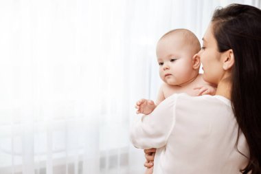 Mutlu anne kucağında ve yeni doğmuş bebeğini kucağında tutuyor.