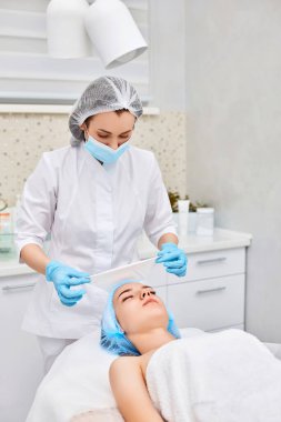 Güzellik uzmanı cildi güzel bir kadından temizliyor. Mükemmel temizlik, spa tedavisi cilt bakımı.