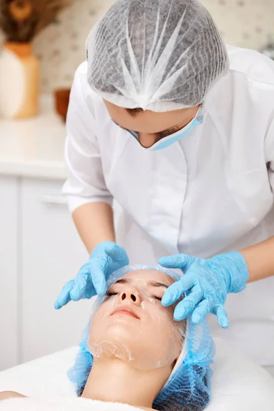 Esthéticienne Applique Masque Feuille Sur Visage Belle Femme Dans Salon — Photo