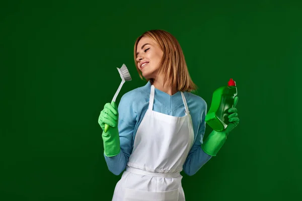 Ładna Kobieta Gumowych Rękawiczkach Trzymająca Szczotkę Butelkę Detergentu Tańczącą Zielonym — Zdjęcie stockowe