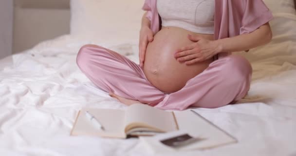 Hamile Bir Kadının Karnını Okşayıp Evdeki Yatakta Oturduğu Görüntüler — Stok video