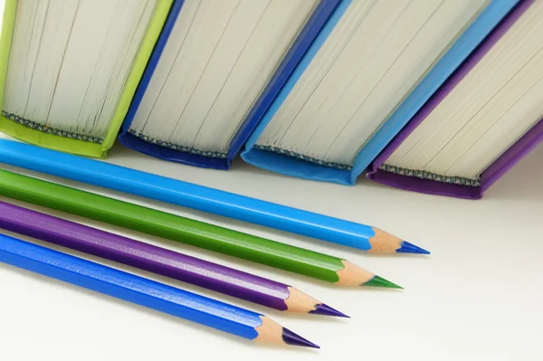 Kitap ve hoş renklerde boya kalemi. — Stok fotoğraf