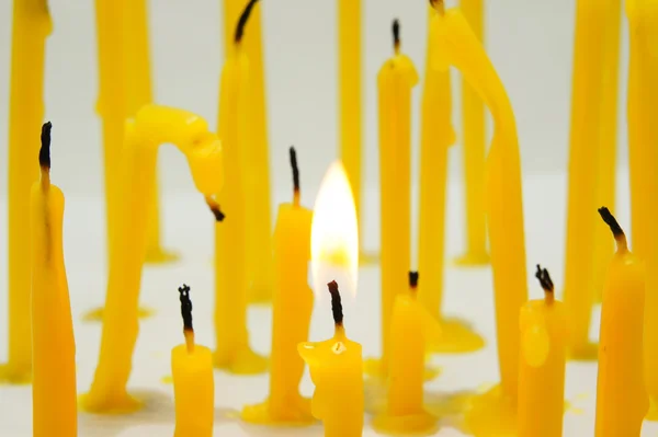 Candle of hope burning on the background of extinct candles. — Stock Photo, Image