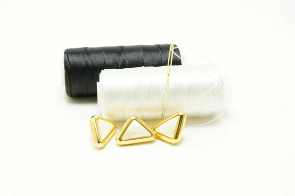 siyah ve beyaz konuları bir iğne ve düğmeler.