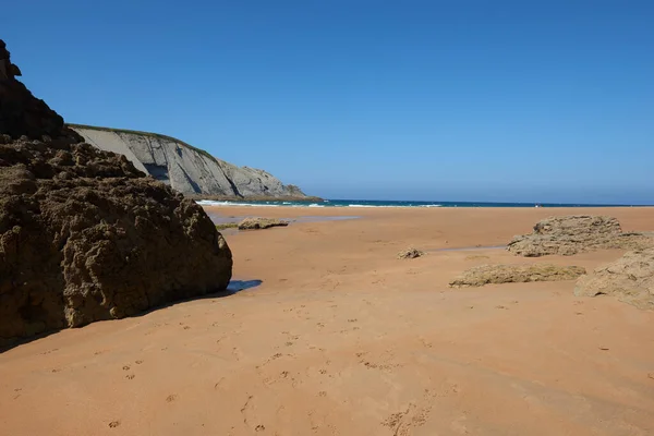 Arka Planda Kayalıklar Olan Sakin Kumlu Bir Sahil — Stok fotoğraf