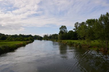 Kıyılarında bol bitki örtüsü olan bir nehrin güzel panoramik manzarası..