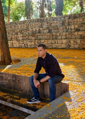 Parkta poz veren kırmızı tişörtlü çekici bir çocuk..