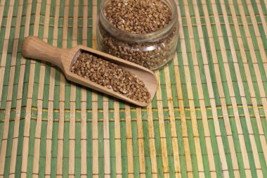 Mutfak spatulasındaki masada karabuğday taneleri var. Yakınlarda karabuğday bankası var..