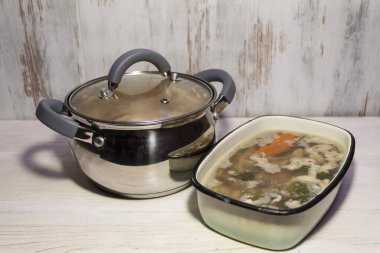 Masanın üzerinde bir tencerede salata ve havuçlu jöleli et, domuz ve tavuk var..