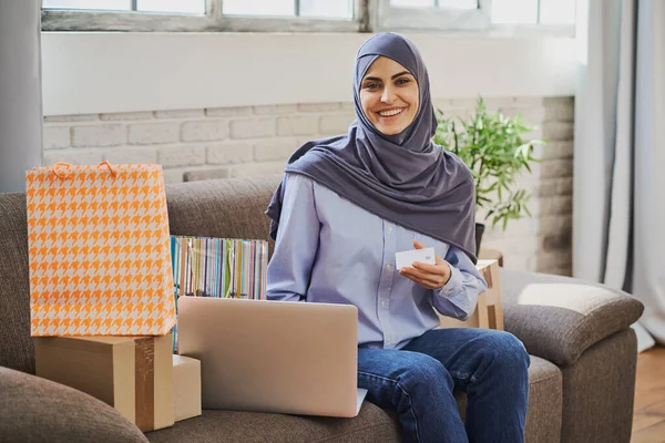 クレジットカードを持っている豪華なアラビア人女性とラップトップを使用して ストックフォト