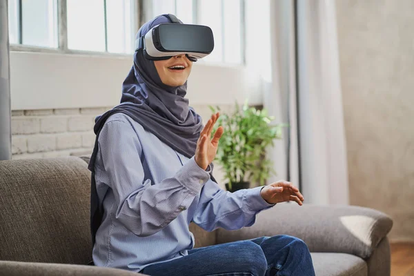 Wanita Muslim yang terpesona menggunakan headset VR untuk pertama kalinya Stok Gambar Bebas Royalti