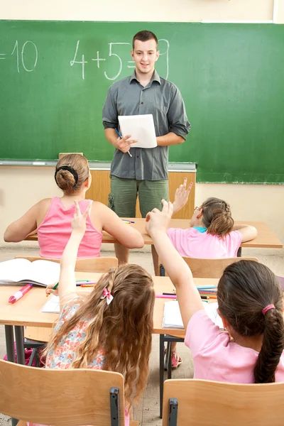 Grundschüler an den Schultischen — Stockfoto