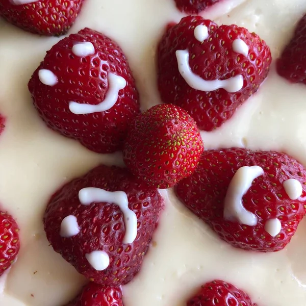 selective focus. Strawberry pie garnished with fresh strawberries. Homemade strawberries cake made from meringue cake and cream with strawberries. Decorated with icing and berries. birthday cake with smiley face.