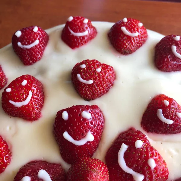 selective focus. Strawberry pie garnished with fresh strawberries. Homemade strawberries cake made from meringue cake and cream with strawberries. Decorated with icing and berries. birthday cake with smiley face.