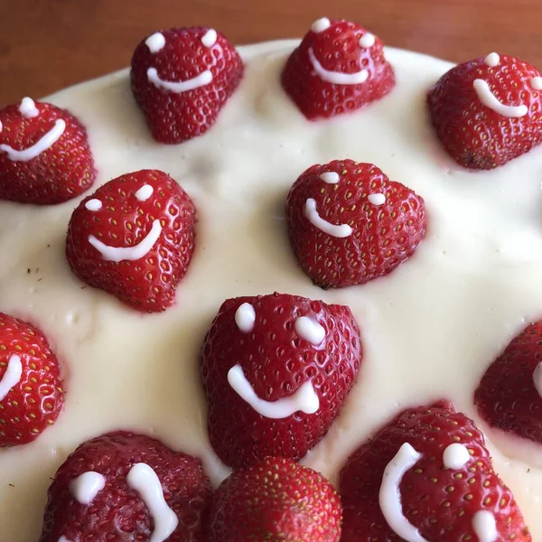 selective focus. Strawberry pie garnished with fresh strawberries. Homemade strawberries cake made from meringue cake and cream with strawberries. Decorated with icing and berries. birthday cake with smiley face.