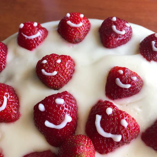 selective focus. Strawberry pie garnished with fresh strawberries. Homemade strawberries cake made from meringue cake and cream with strawberries. Decorated with icing and berries. birthday cake with smiley face.